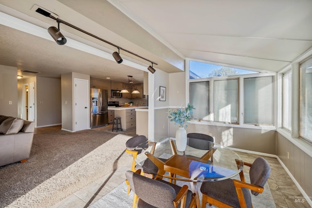 sunroom with vaulted ceiling, rail lighting, and a healthy amount of sunlight