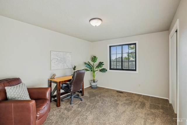 carpeted office featuring visible vents and baseboards