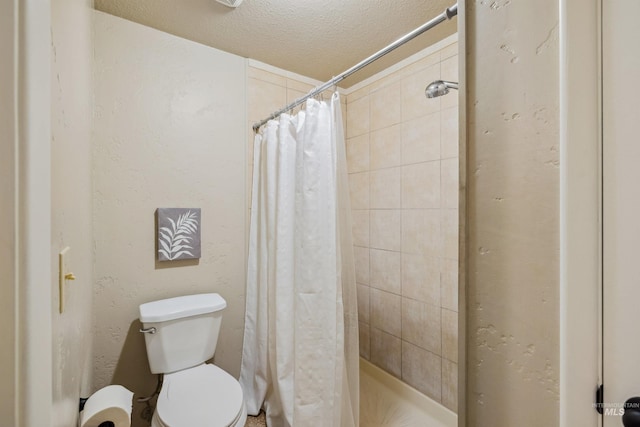 bathroom with toilet, a stall shower, and a textured ceiling