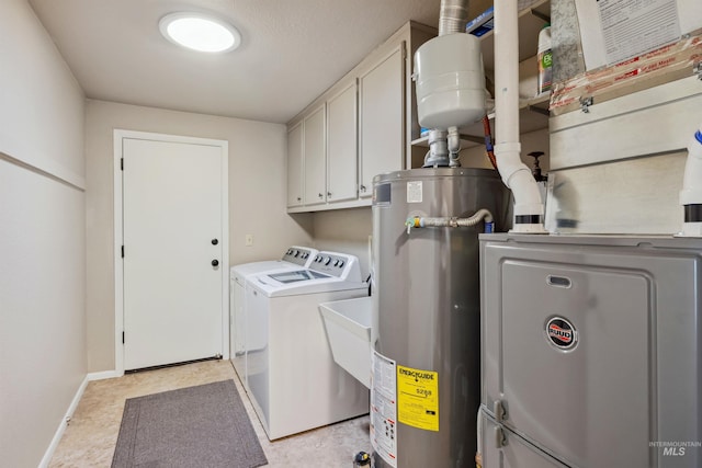 laundry area with washer and dryer, water heater, cabinet space, and baseboards