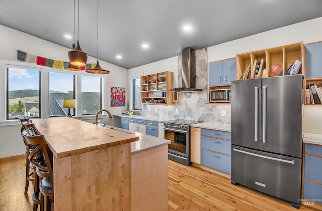 2809 Hampton Ct, Moscow, ID 83843 - kitchen featuring stainless steel appliances, wall chimney range hood, backsplash, butcher block counters, and open shelves