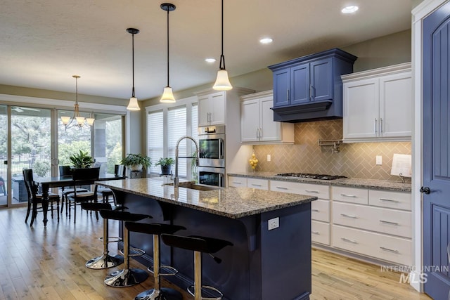 3214 S Arctic Fox Ave, Eagle, ID 83616 - kitchen with plenty of natural light, decorative backsplash, light wood-style flooring, light stone counters, and recessed lighting