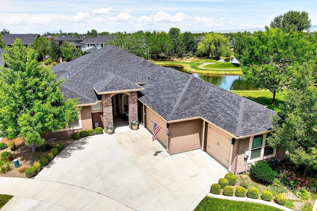 3214 S Arctic Fox Ave, Eagle, ID 83616 - view of front facade featuring a shingled roof, a garage, stucco siding, concrete driveway, and a water view