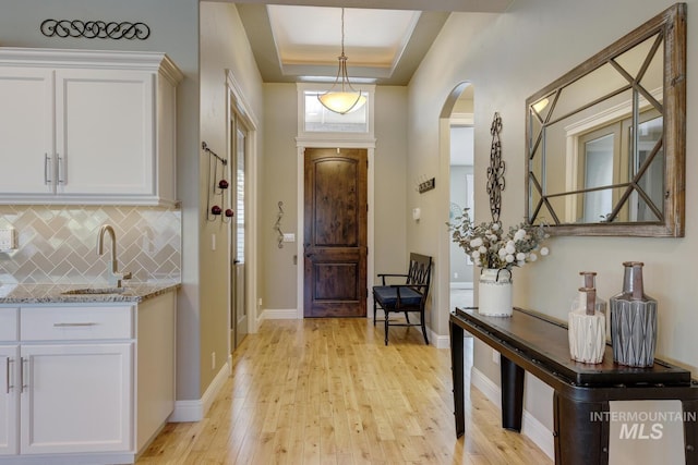 3214 S Arctic Fox Ave, Eagle, ID 83616 - foyer with arched walkways, light wood-style floors, and a raised ceiling