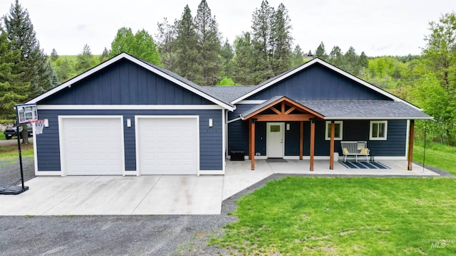 1147 Driscoll Ridge Rd, Troy, ID 83871 - ranch-style house featuring a porch, a front lawn, roof with shingles, a garage, and board and batten siding