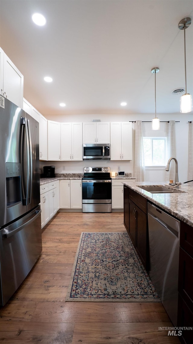1147 Driscoll Ridge Rd, Troy, ID 83871 - kitchen with appliances with stainless steel finishes, a sink, decorative light fixtures, white cabinets, and wood finished floors
