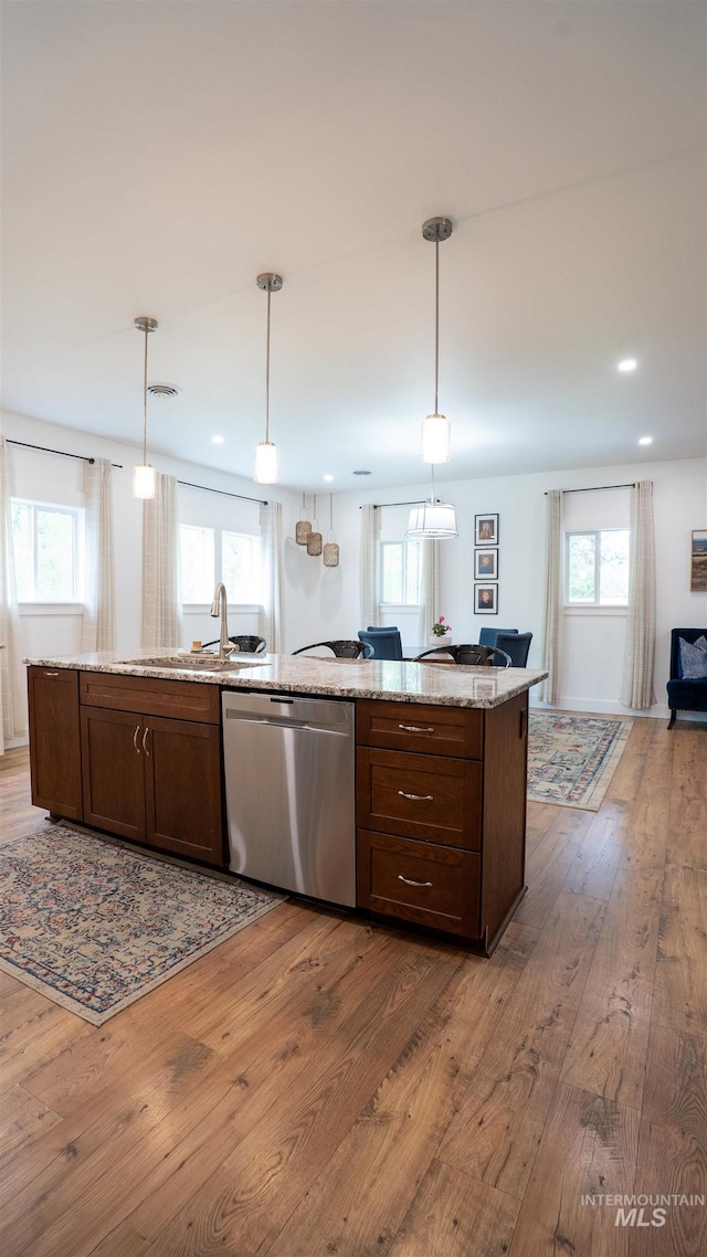 1147 Driscoll Ridge Rd, Troy, ID 83871 - kitchen featuring stainless steel dishwasher, a sink, open floor plan, hardwood / wood-style floors, and light stone counters