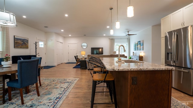 1147 Driscoll Ridge Rd, Troy, ID 83871 - kitchen featuring stainless steel fridge with ice dispenser, a sink, open floor plan, a center island with sink, and light wood-style floors