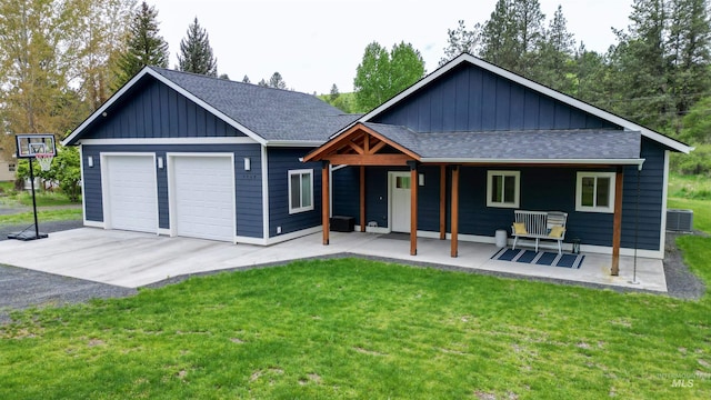 1147 Driscoll Ridge Rd, Troy, ID 83871 - view of front facade featuring a shingled roof, central AC unit, board and batten siding, and a front yard