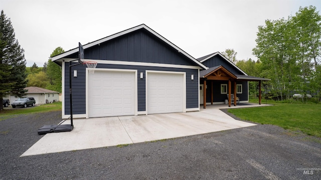 1147 Driscoll Ridge Rd, Troy, ID 83871 - view of front of home featuring a garage, a front yard, covered porch, and board and batten siding