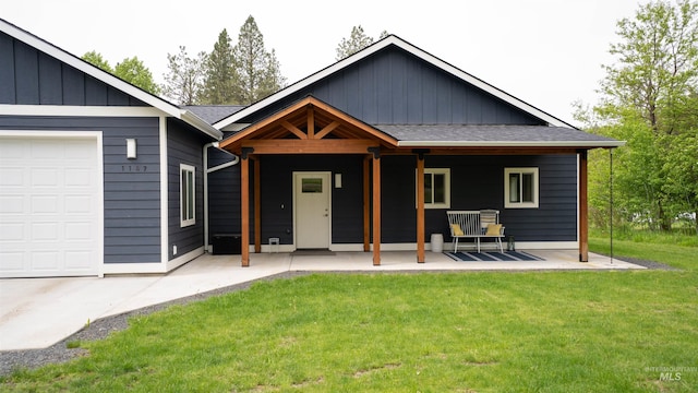 1147 Driscoll Ridge Rd, Troy, ID 83871 - view of front of house featuring a front lawn, board and batten siding, covered porch, and an attached garage