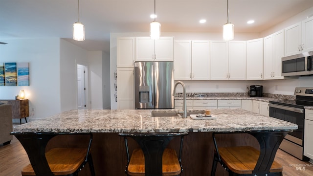1147 Driscoll Ridge Rd, Troy, ID 83871 - kitchen featuring stainless steel appliances, a sink, light wood-style floors, a kitchen breakfast bar, and recessed lighting