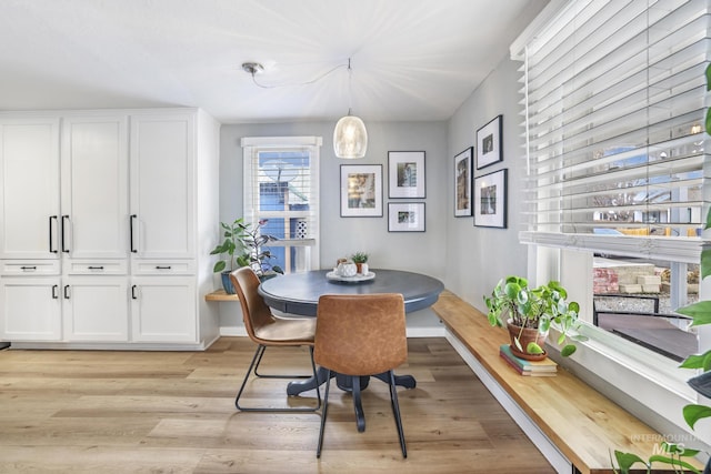 dining room with breakfast area, light wood-type flooring, and baseboards