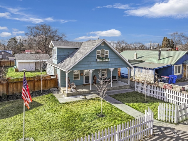 back of property featuring a shingled roof, fence private yard, and a yard