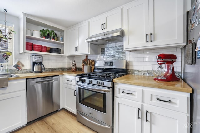 kitchen featuring wooden counters, appliances with stainless steel finishes, white cabinets, and under cabinet range hood