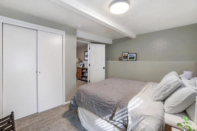 carpeted bedroom with a closet and beamed ceiling