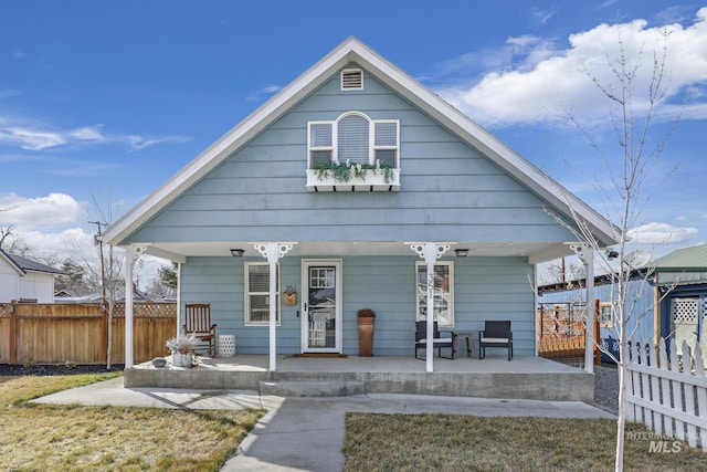 bungalow-style house with a porch and fence