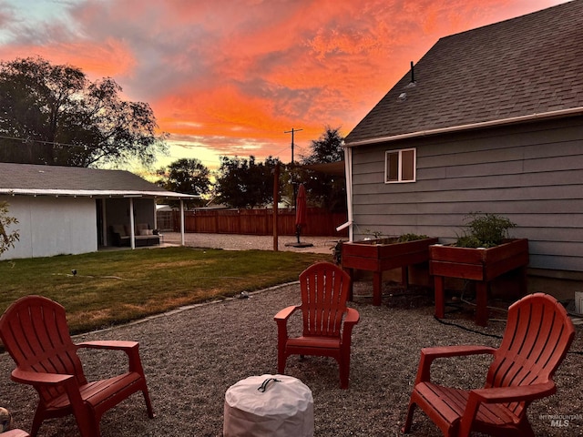 yard at dusk featuring a patio area and fence