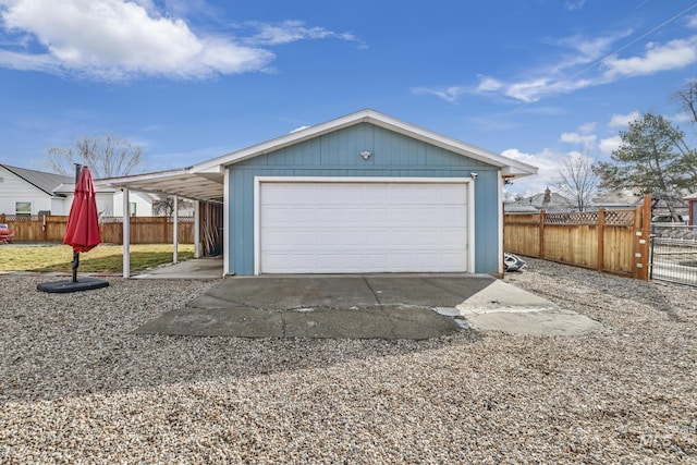 garage featuring fence and a detached garage