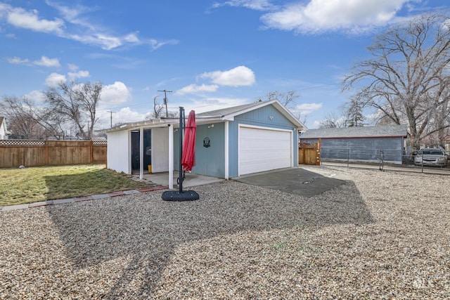 ranch-style home featuring an outbuilding, a front lawn, fence, and a garage