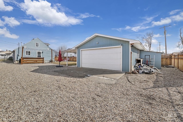 detached garage featuring fence