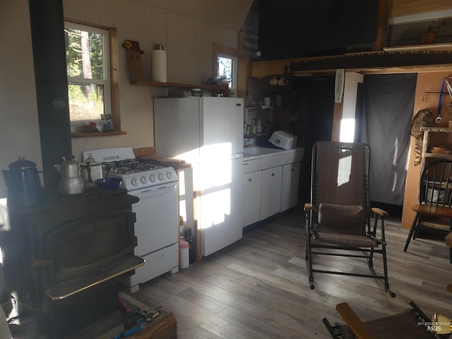 309 Wildrose Ln, Anatone, WA 99401 - kitchen with washer / clothes dryer, light hardwood / wood-style flooring, white cabinets, and white appliances