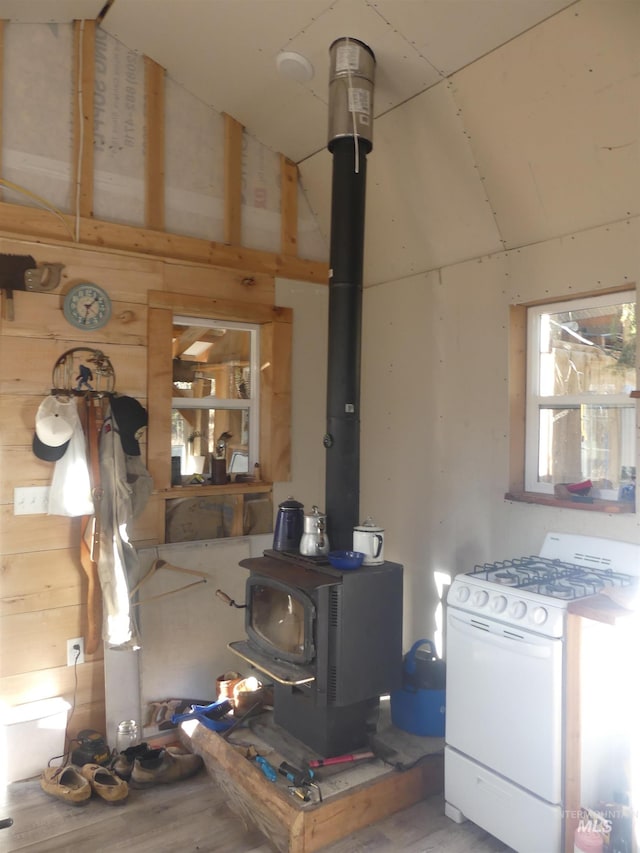 309 Wildrose Ln, Anatone, WA 99401 - interior space with hardwood / wood-style floors, a wood stove, white gas range, and wooden walls