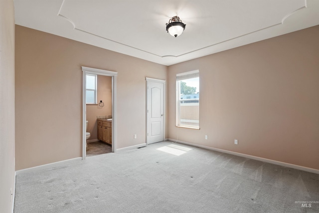 1141 Liberty Dr, Clarkston, WA 99403 - unfurnished bedroom featuring light carpet, baseboards, and connected bathroom