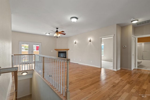 1141 Liberty Dr, Clarkston, WA 99403 - empty room with a ceiling fan, light wood-style flooring, a tiled fireplace, baseboards, and a smoke detector