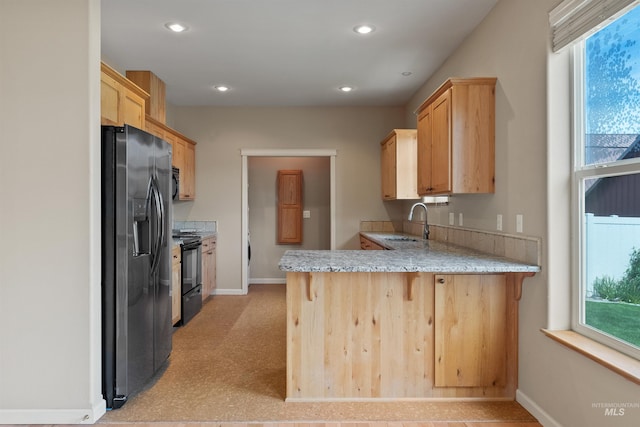 1141 Liberty Dr, Clarkston, WA 99403 - kitchen with fridge with ice dispenser, black electric range oven, a sink, a peninsula, and baseboards