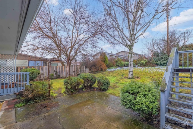 view of yard with a patio, stairway, and fence