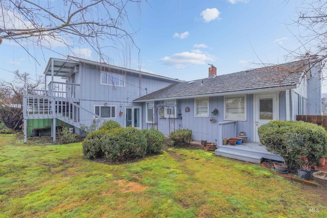 view of front of home featuring stairway, a front yard, and a chimney