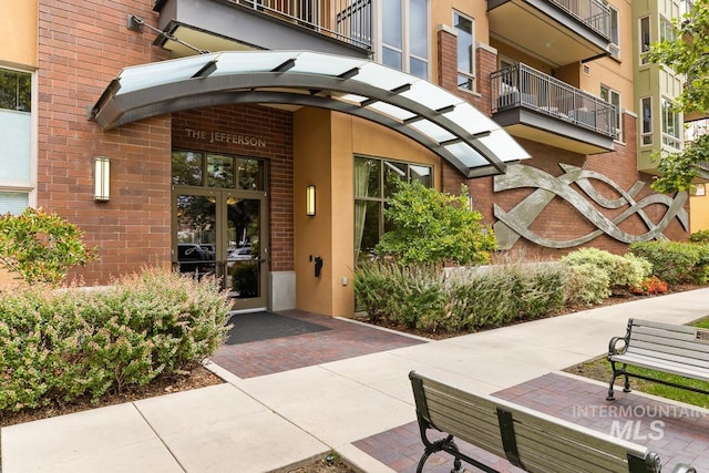 view of exterior entry with a balcony