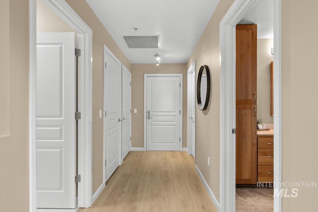 hall with light hardwood / wood-style flooring and sink