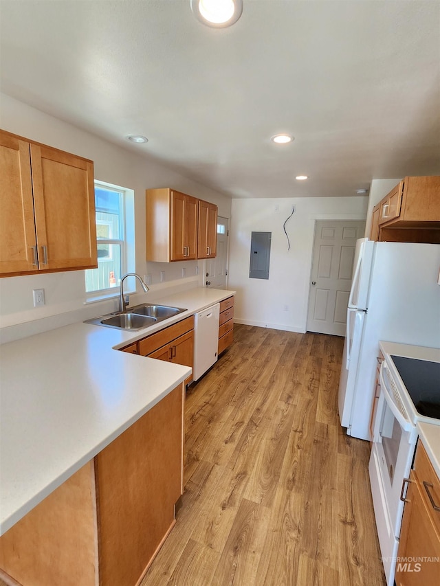 kitchen featuring electric panel, sink, kitchen peninsula, white appliances, and light hardwood / wood-style floors