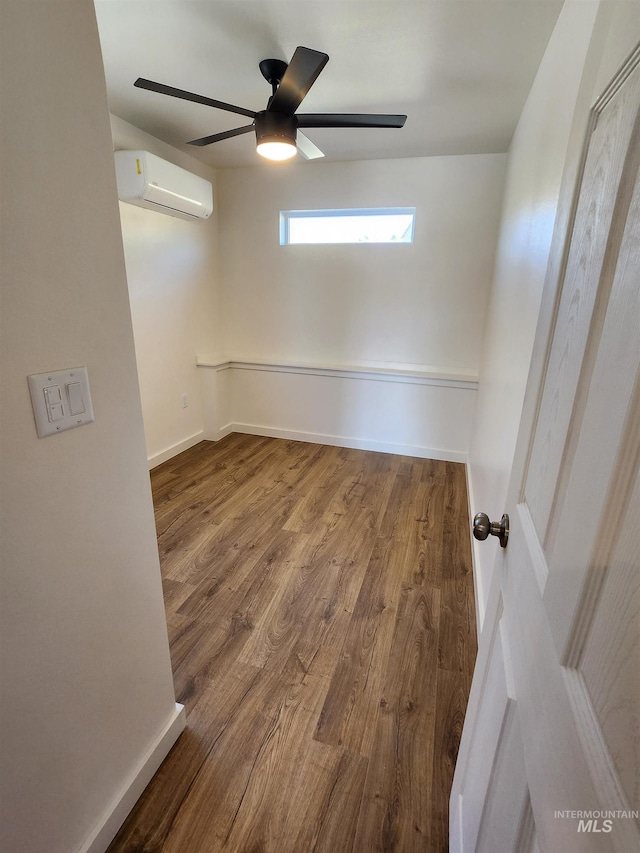 spare room featuring ceiling fan, hardwood / wood-style floors, and a wall mounted air conditioner