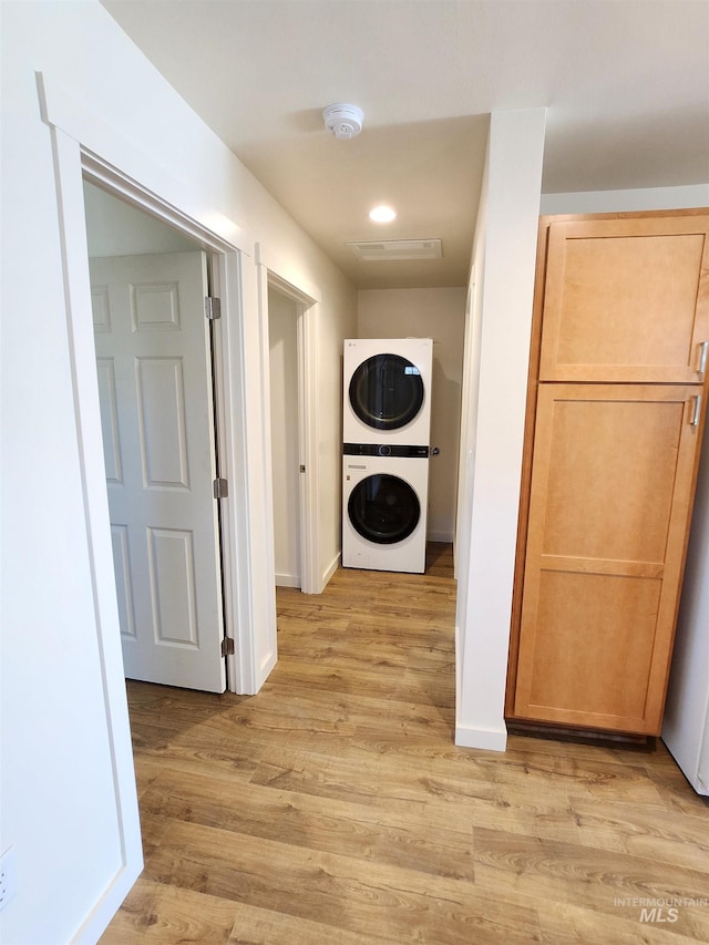 hall featuring light hardwood / wood-style flooring and stacked washer / drying machine