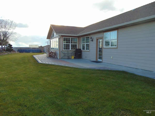 back of house with a patio and a yard