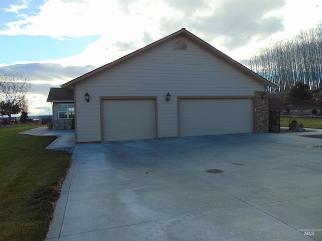 view of side of property featuring a lawn and a garage