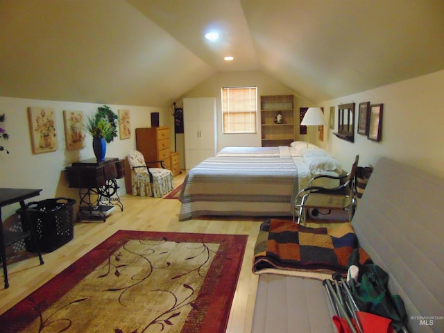 bedroom with light wood-type flooring and lofted ceiling