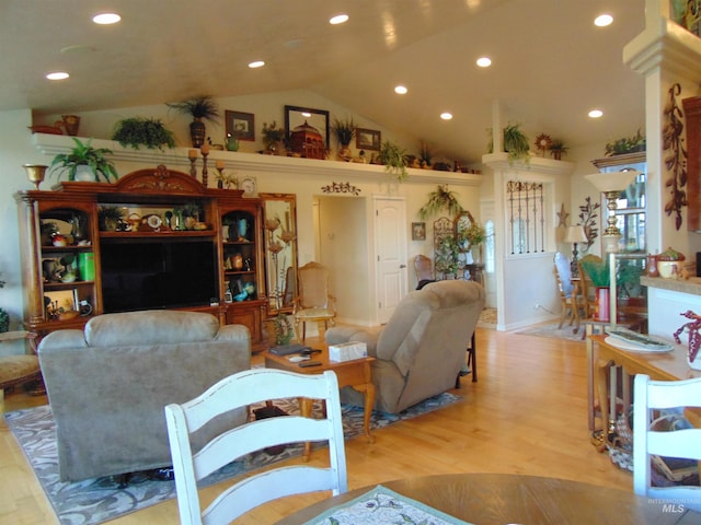 living room featuring light wood-type flooring and vaulted ceiling