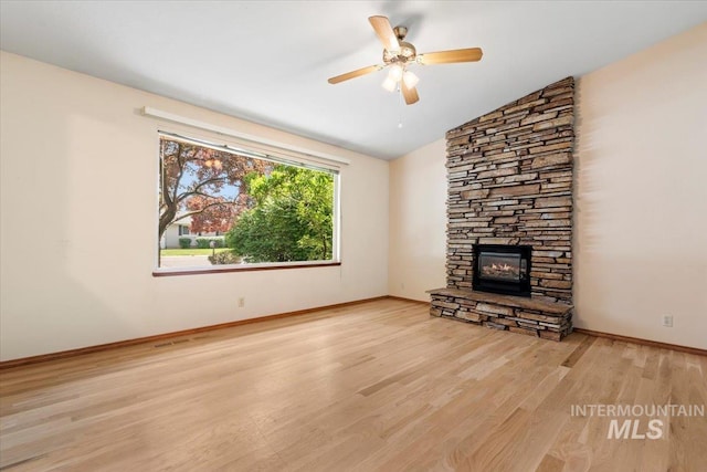 3493 N Buckboard Way, Boise, ID 83713 - unfurnished living room featuring wood finished floors, a stone fireplace, lofted ceiling, and a ceiling fan