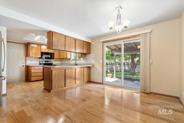 3493 N Buckboard Way, Boise, ID 83713 - kitchen featuring black microwave, a peninsula, brown cabinets, light countertops, and light wood-style flooring
