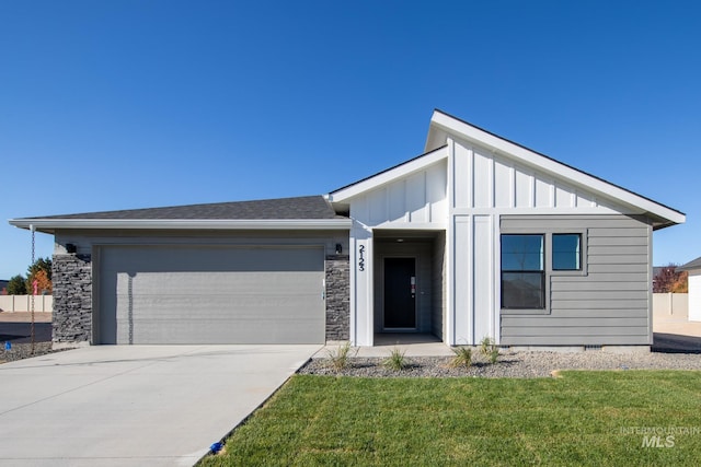 view of front of home featuring a front yard, driveway, stone siding, a garage, and board and batten siding