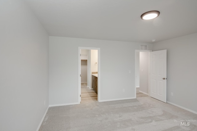 unfurnished bedroom featuring visible vents, baseboards, and light carpet