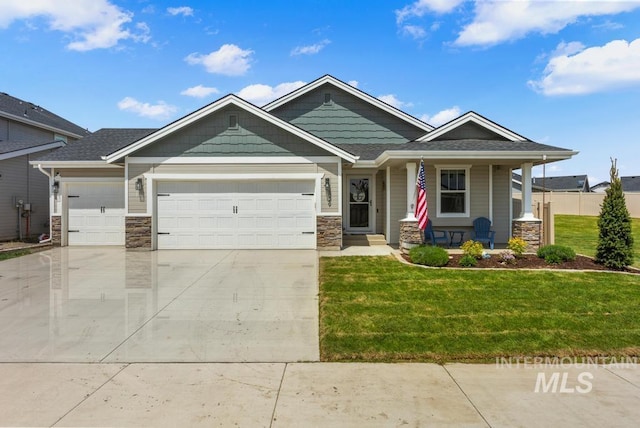 2829 N Cherry Grove Way, Star, ID 83669 - craftsman-style house featuring a garage, a porch, a front yard, concrete driveway, and stone siding