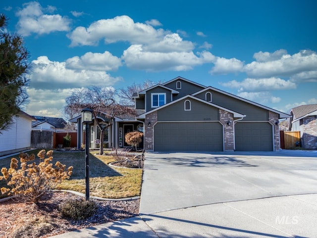 traditional home with a garage, fence, concrete driveway, and brick siding