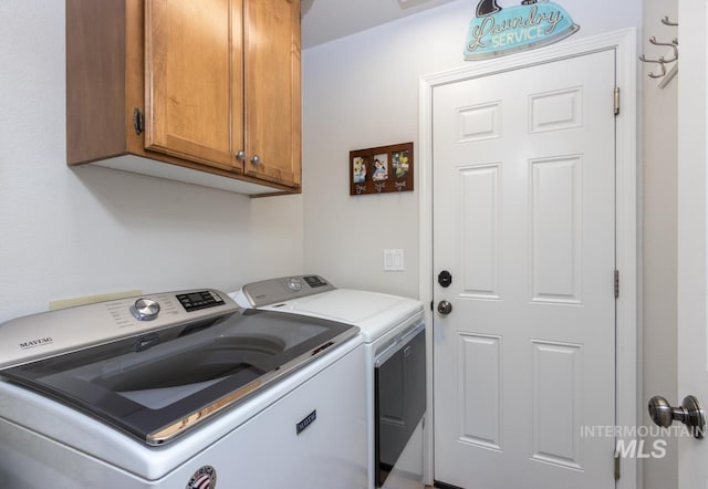 washroom with cabinet space and washer and dryer