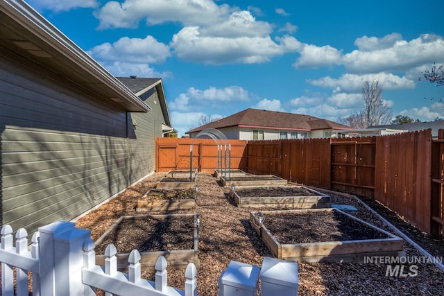 view of yard with fence and a vegetable garden