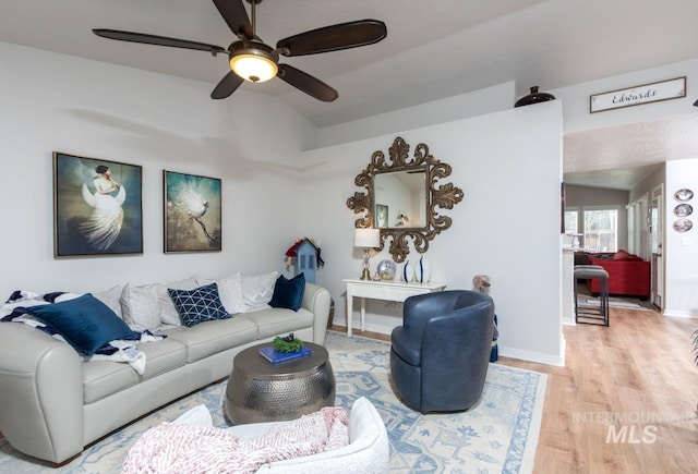 living room with vaulted ceiling, ceiling fan, wood finished floors, and baseboards